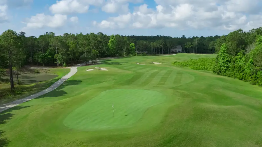 Leopards Chase Golf Club wide fairway through pines with a cart path along the left